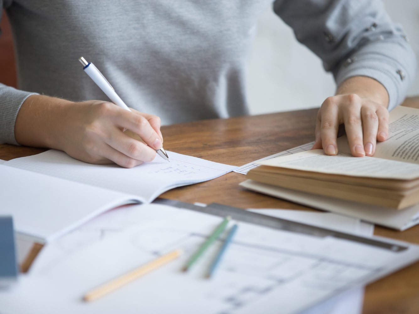 Person macht Notizen am Schreibtisch